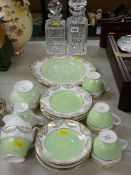 Two excellent decanters with stoppers and a fifteen piece green and gilt teaset