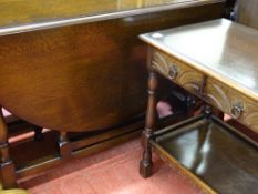 Mahogany drop leaf dining table and a two tier hall table with carved drawers and metal ring