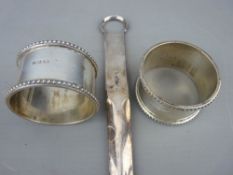 Pair of silver napkin rings and a white metal meat skewer