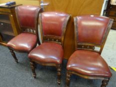 Set of three leather upholstered scroll back chairs