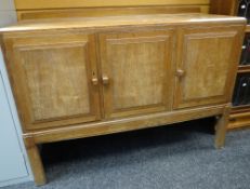 A Brynmawr Furniture Makers oak railback sideboard having three cupboard doors and bearing