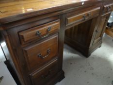 A good modern hardwood desk with drawers and cupboard to the base, 145cms wide