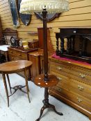 A tripod mahogany standard lamp with circular shelf