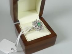 A modern 14ct white gold diamond and emerald ring of sunburst form with centred emerald and outer
