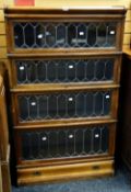 A good oak four-section leaded glass fronted Globe Wernicke bookcase with a drawer base, 146cms high