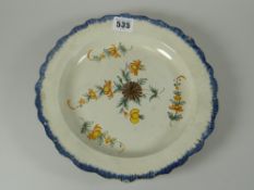 An early nineteenth century creamware dish, centred with painted flowers and with a brushed blue