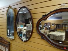 A vintage bevelled wall mirror of shaped form with moulded border to the frame together with an oval