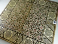 An Islamic-style mother of pearl inlaid folding games board, drafts & chess board on outside with