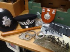 Quantity of assorted police related items to include truncheon, hats, handcuffs, pictures,