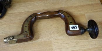 An antique walnut and brass hand brace tool
