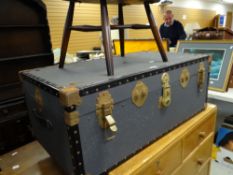 An Ercol tub-type chair together with a vintage steamer trunk