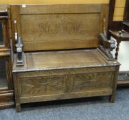 A good vintage carved oak monk's bench with box seat and carved lion-form arms, 105cms wide