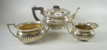 A three-piece oval based silver teaset of teapot, cream jug and twin-handled sugar basin of fluted