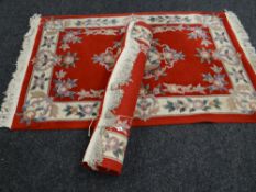 Pair of red ground Chinese-style wash rugs (2)