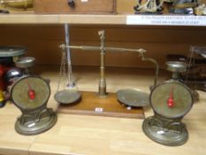 A set of brass provision scales with circular dishes on a wooden stand and together with a pair of