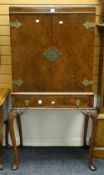 A good reproduction burr walnut standing cocktail cabinet with base drawer and brass mounts over