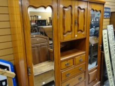 An Edwardian mahogany wardrobe with chest of drawers and linen cupboard combination and flanking