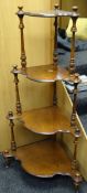 An antique burr walnut four-tier whatnot with shaped shelves and turned supports
