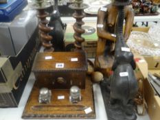 A good vintage oak desk tidy with lidded box and inkwells, carved wooden elephant lamps, two