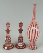 A Venetian striped glass bottle vase, 34cms high and a pair of red and clear glass fancy bell-shaped