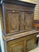 A continental carved cupboard-dresser, 124cms wide