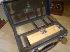 A vintage leather cased set of weights with fitted wooden box