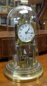A vintage brass and glass domed perpetual clock