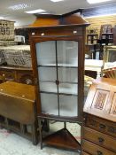 A neat mahogany and inlaid standing corner cabinet with railback, glazed upper door and bottom