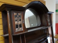 An Art Nouveau-style mirror back mahogany overmantel with side cabinets and having decorative copper