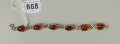 A silver gilt fancy bracelet set with six believed amber ovals Please note: