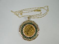 A 1908 gold full-sovereign within a filigree mount set with green gemstones, attached to a fine