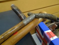 Three walking sticks including one with believed silver band