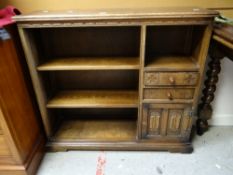 A reproduction oak open bookcase with two drawers and linen fold cupboard, 93cms wide