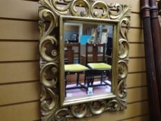 A decorative rococo-style gilt framed mirror, 64 x 53cms