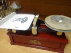 A set of vintage scales with ceramic dish bearing transfer heraldic crest on a wooden stand, 51cms