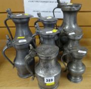 A COLLECTION OF EIGHT PEWTER FLAGONS of pot-bellied form, all lidded with twin-acorn thumb pieces,