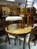 A GOOD VINTAGE LIGHT OAK CIRCULAR EXTENDING DINING TABLE with shaped legs, together with 3 + 2