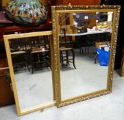 A MODERN GILT-DECORATED BEVELLED WALL MIRROR and another
