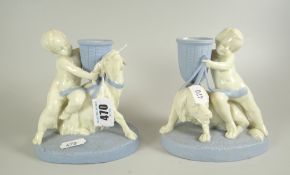A PAIR OF ROYAL WORCESTER PORCELAIN MODELS OF PUTTI with spillholder vases, one accosting a goat,