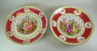 A PAIR OF AUSTRIAN PORCELAIN CHARGER DISHES, typically decorated with centred classical panels in