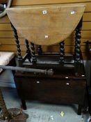 A VINTAGE DROP-LEAF TABLE in light oak having barley-twist gate legs and another