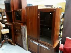 A COLLECTION OF DARK TEAK MODULAR LOUNGE UNITS including wall cupboard, glass doored cupboards etc.