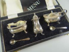 A CASED SILVER CONDIMENT SET comprising silver salt and matching mustard pots and pepperette with