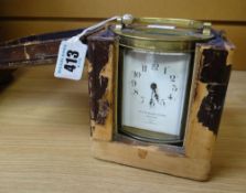 CARRIAGE CLOCK in brass and of oval shape raised on four feet with French movement, the dial