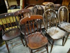 A SET OF FOUR VINTAGE STAINED PINE WHEELBACK KITCHEN CHAIRS, together with three others (7)