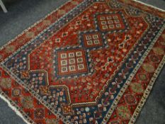A RED GROUND RUG with blue & white geometric pattern with ewers, fringed, 222 x 164cms
