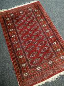 EASTERN DESIGN RED GROUND SMALL RUG having central field of guls within geometric borders