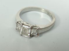 PLATINUM SET LADIES THREE STONE EMERALD CUT DIAMOND RING. The central stone an approximate weight of