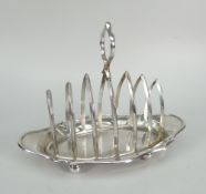 GEORGE V SILVER SIX SECTION TOAST RACK OF OVAL FORM raised on four ball feet with loop handle.