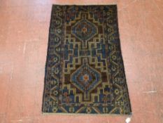 AN OLD BELUCHI RUG, brown and blue ground, triple bordered with central double block pattern, 123